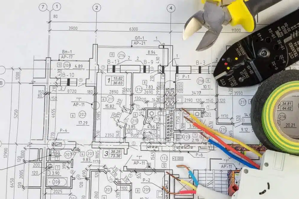 Rysunek techniczny instalacji elektrycznej z miernikiem, przewodami i narzędziami